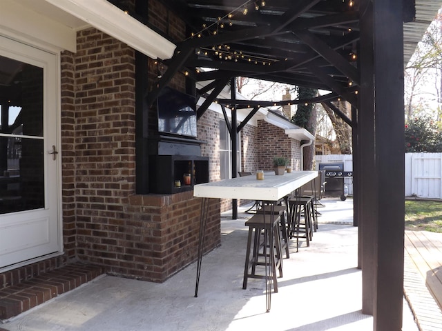 view of patio featuring area for grilling, outdoor dining area, and fence