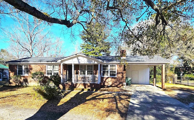 single story home with a carport, concrete driveway, brick siding, and covered porch