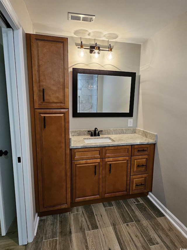 bathroom featuring vanity, baseboards, visible vents, and wood finish floors