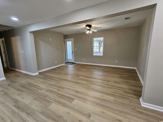 spare room featuring ceiling fan, visible vents, baseboards, and wood finished floors