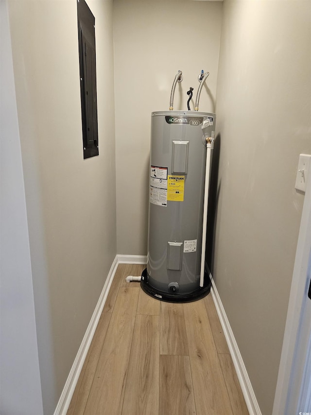 utility room featuring electric panel and electric water heater