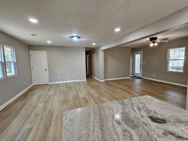 unfurnished living room with visible vents, a ceiling fan, recessed lighting, light wood-style floors, and baseboards