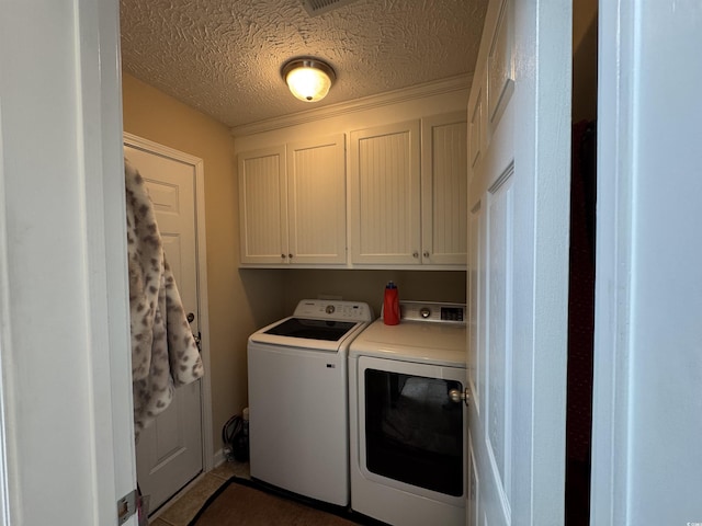 laundry area featuring cabinet space, a textured ceiling, and independent washer and dryer