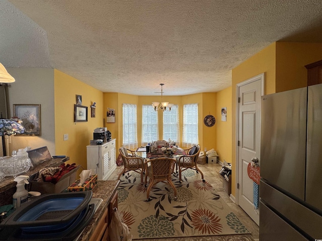 dining room with a textured ceiling and a chandelier