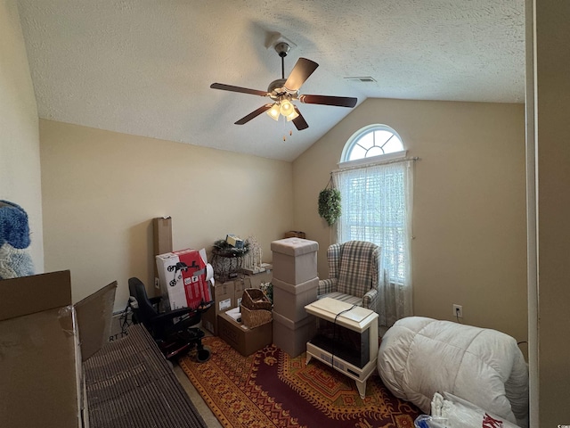 interior space with a textured ceiling, vaulted ceiling, and ceiling fan