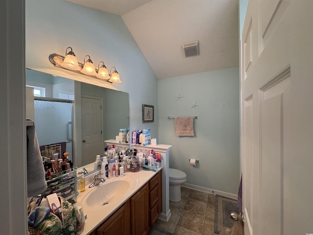 bathroom with visible vents, toilet, a shower stall, vanity, and vaulted ceiling