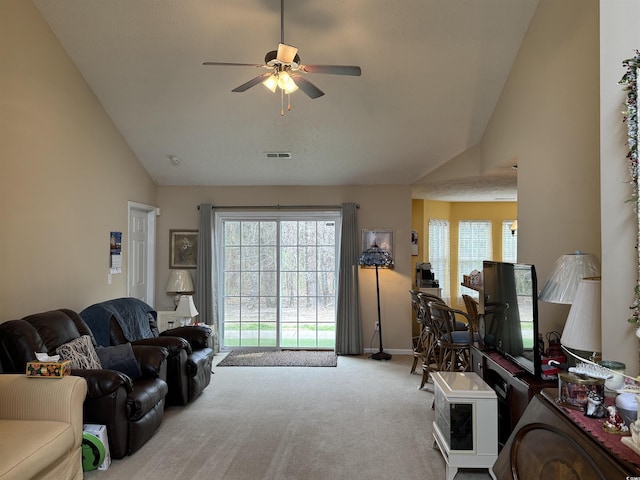 carpeted living room with baseboards, visible vents, high vaulted ceiling, and ceiling fan