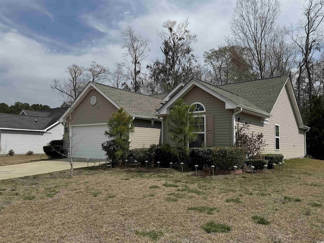 ranch-style house featuring concrete driveway, a garage, a front yard, and roof with shingles