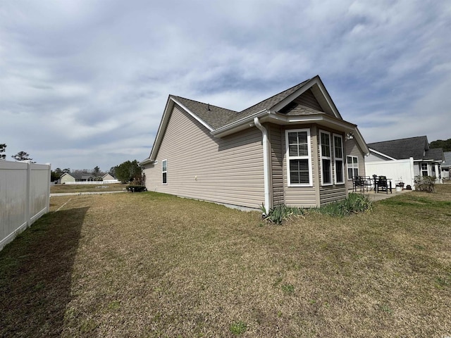 view of home's exterior featuring a yard, a patio, and fence