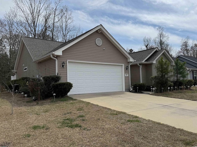 view of home's exterior with an attached garage, a shingled roof, and concrete driveway