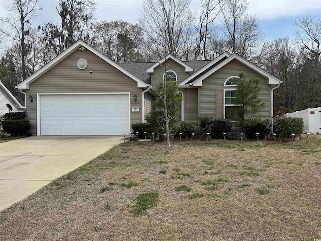 ranch-style home featuring driveway, a garage, and fence