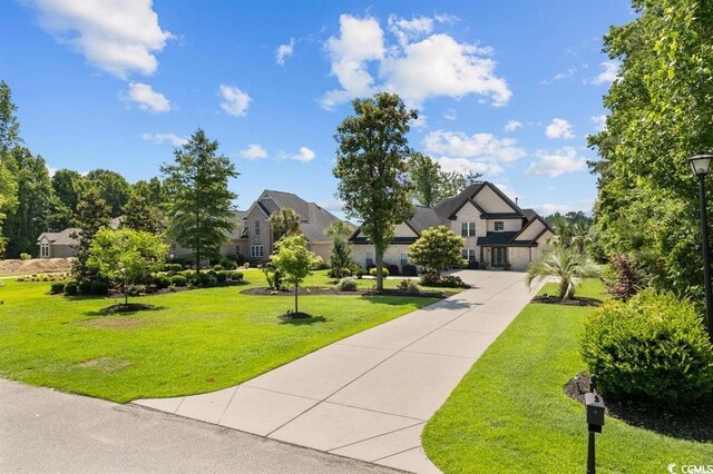 view of front of property with driveway and a front lawn