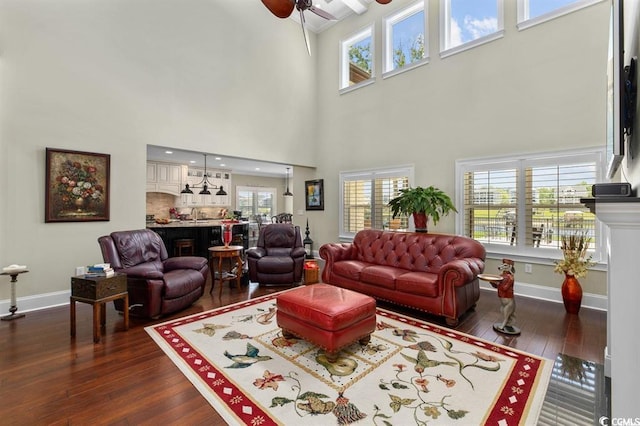 9785 Anchor Dr, Longs, SC 29568 - living room featuring plenty of natural light, a ceiling fan, dark wood-style flooring, baseboards, and a high ceiling