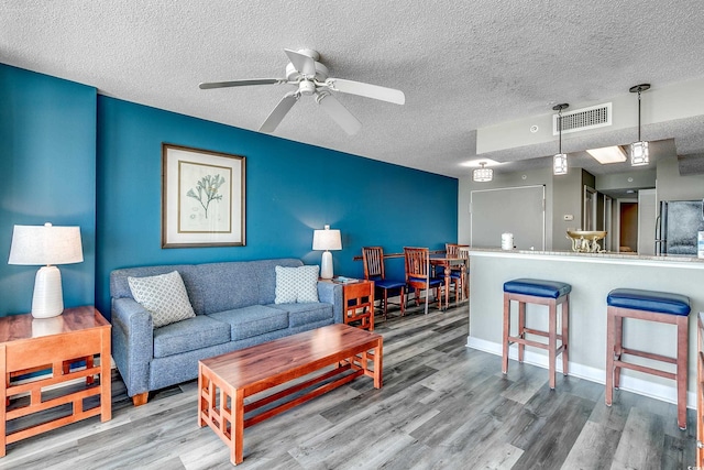 5300 N Ocean Blvd Unit 1003, Myrtle Beach, SC 29577 - living room featuring a ceiling fan, wood finished floors, visible vents, and a textured ceiling