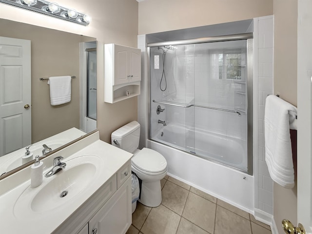 full bathroom featuring tile patterned floors, bath / shower combo with glass door, vanity, and toilet