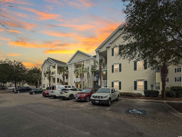 property at dusk featuring uncovered parking