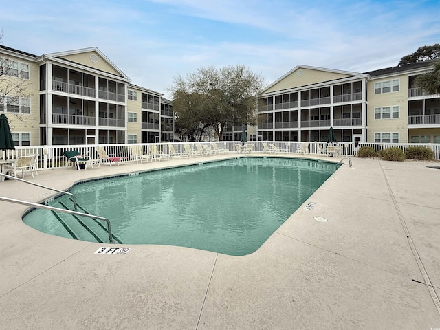 community pool with fence and a patio