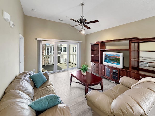 living room with a ceiling fan, visible vents, lofted ceiling, and light wood-style floors