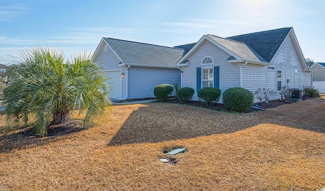 single story home with central AC, an attached garage, and a shingled roof