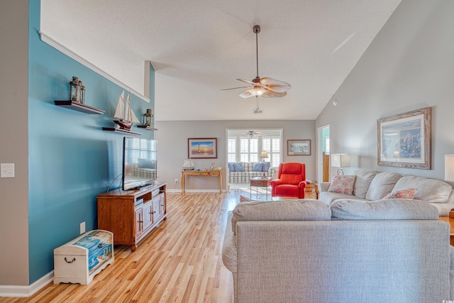 living room with lofted ceiling, baseboards, light wood-style floors, and a ceiling fan