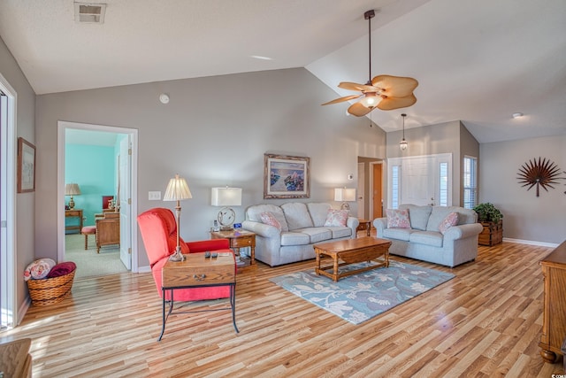 living area featuring baseboards, visible vents, a ceiling fan, and light wood-style floors