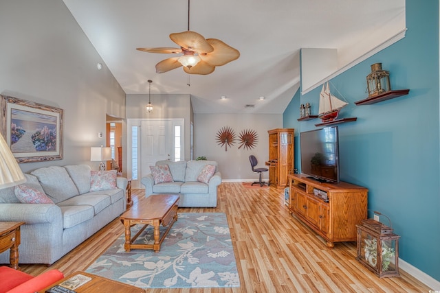 living room featuring baseboards, high vaulted ceiling, a ceiling fan, and light wood finished floors