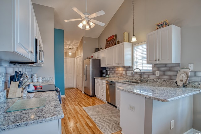 kitchen with a ceiling fan, a peninsula, a sink, appliances with stainless steel finishes, and white cabinetry