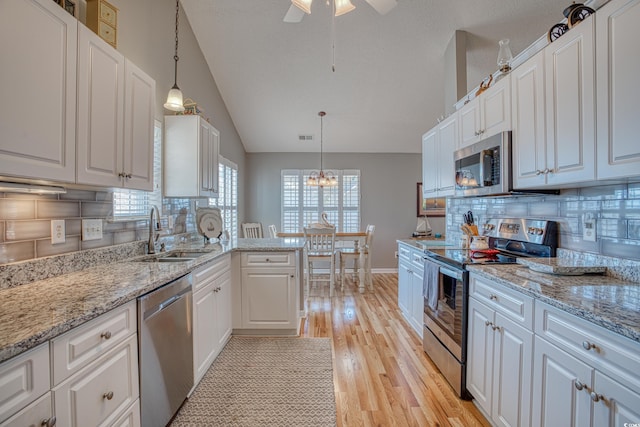 kitchen featuring a sink, ceiling fan with notable chandelier, appliances with stainless steel finishes, and white cabinetry