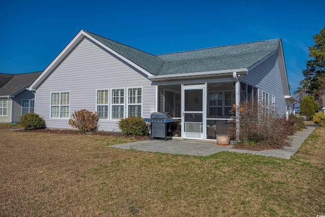 back of house featuring a yard, a patio area, a sunroom, and roof with shingles