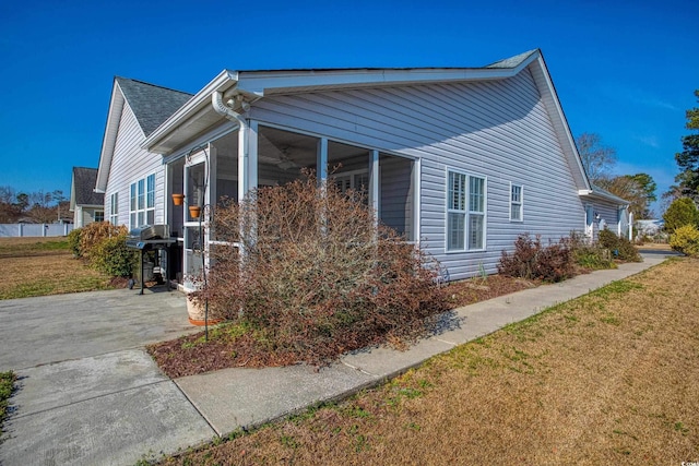 view of home's exterior with a lawn and a sunroom