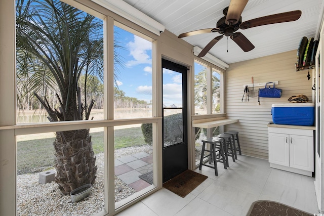 sunroom / solarium featuring a ceiling fan