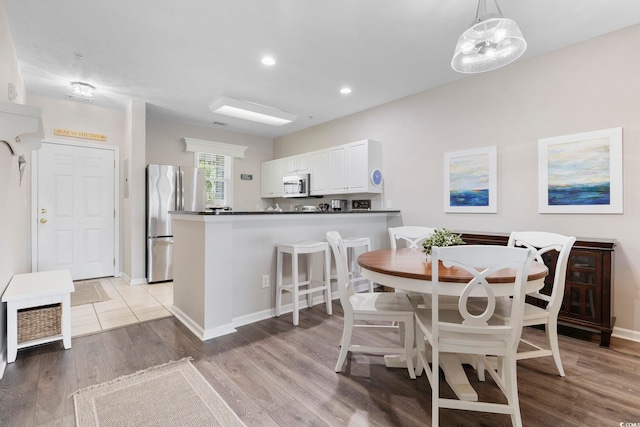 dining room featuring recessed lighting, baseboards, and light wood-style floors