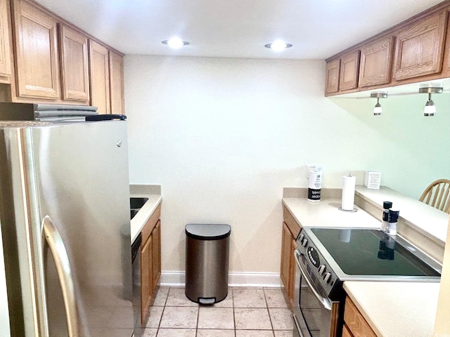 kitchen featuring light countertops, light tile patterned floors, brown cabinets, and appliances with stainless steel finishes