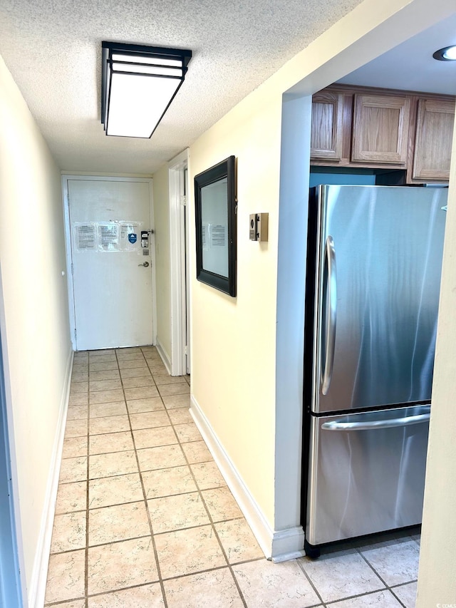 hall with baseboards and a textured ceiling