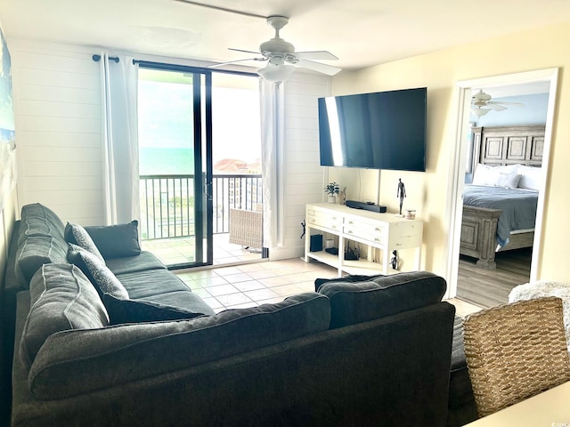 living area with light tile patterned floors and ceiling fan