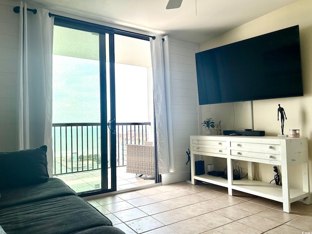 tiled living room with a wall of windows and ceiling fan