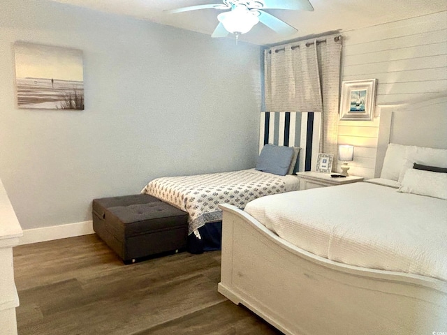 bedroom featuring dark wood-type flooring, a ceiling fan, and baseboards