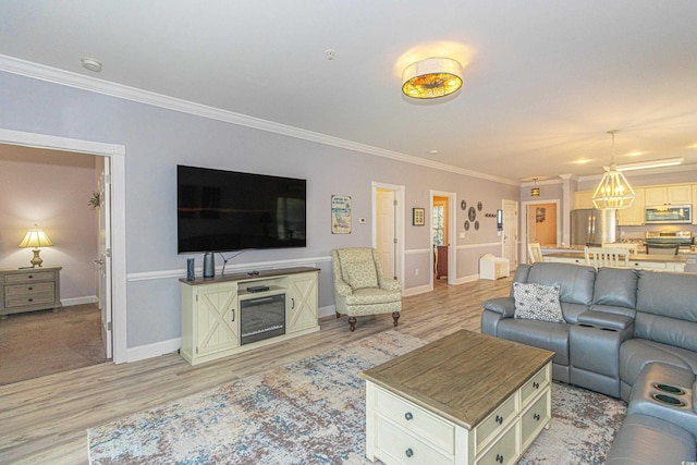 living room featuring light wood-style flooring, crown molding, and baseboards