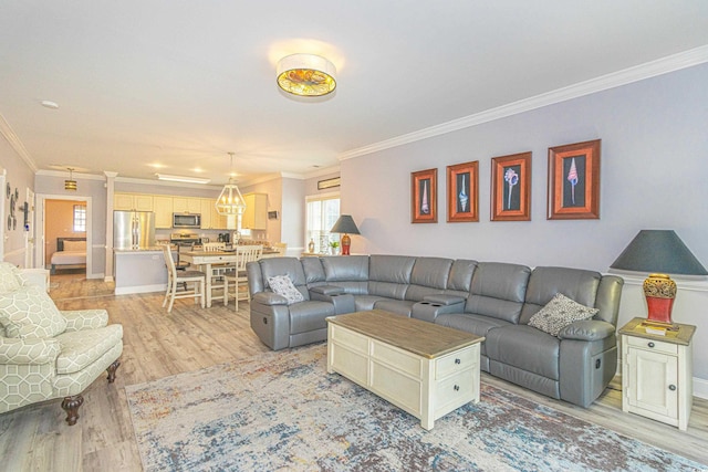 living area with crown molding, light wood-style flooring, and baseboards