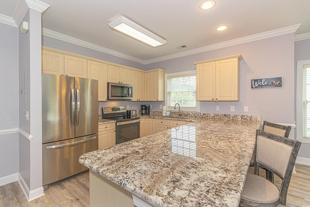 kitchen with a peninsula, visible vents, light wood finished floors, and stainless steel appliances