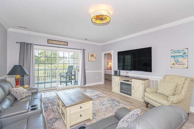 living room with visible vents, baseboards, light wood-style floors, and ornamental molding