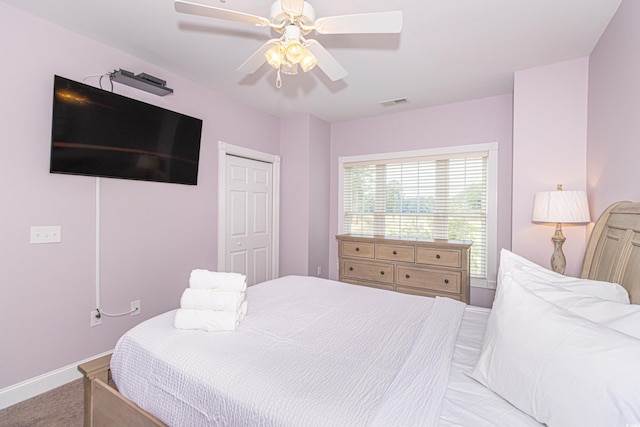 bedroom with visible vents, a ceiling fan, a closet, carpet floors, and baseboards