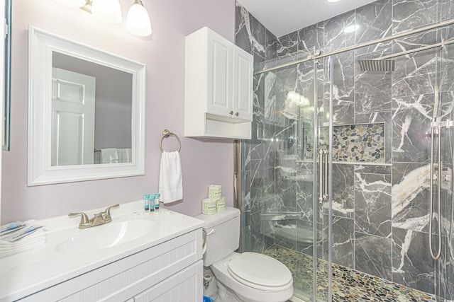 bathroom with a marble finish shower, toilet, and vanity