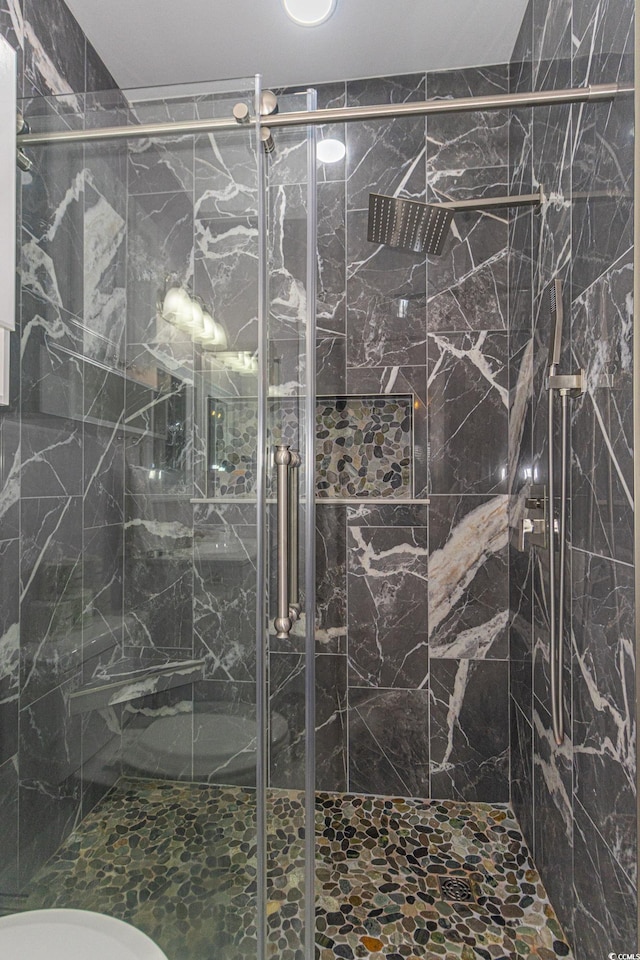 full bathroom featuring a marble finish shower and toilet