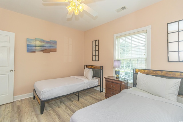 bedroom with visible vents, baseboards, light wood-style floors, and a ceiling fan