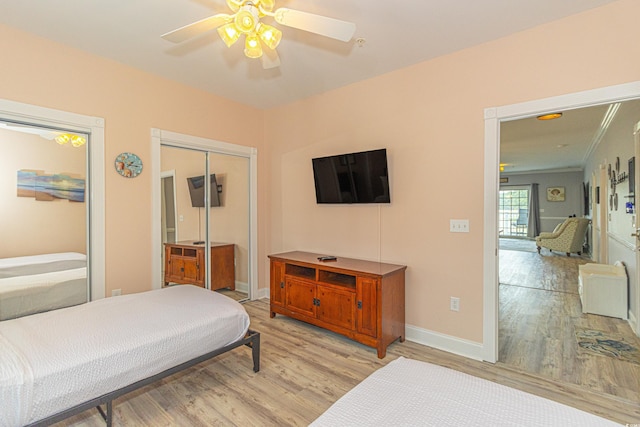 bedroom with a closet, ceiling fan, baseboards, and light wood-style floors