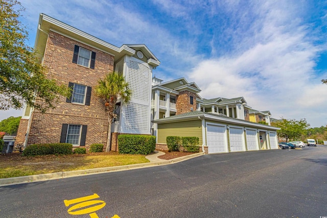 view of front of property with community garages and brick siding