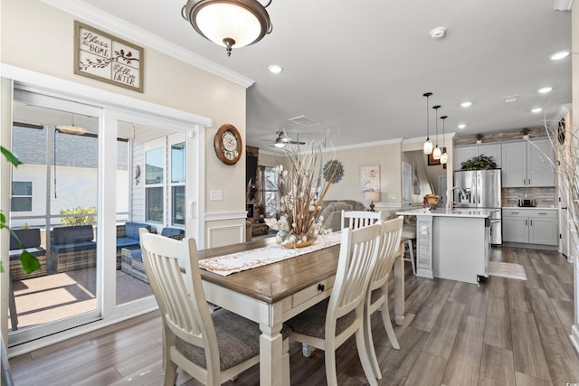 dining room with crown molding, recessed lighting, dark wood-style floors, and wainscoting