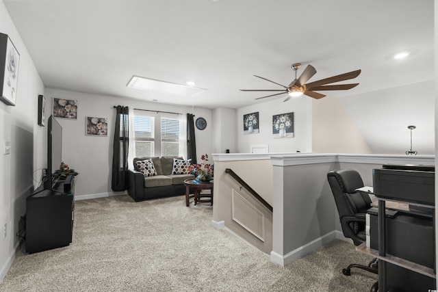 office featuring light carpet, baseboards, attic access, and ceiling fan