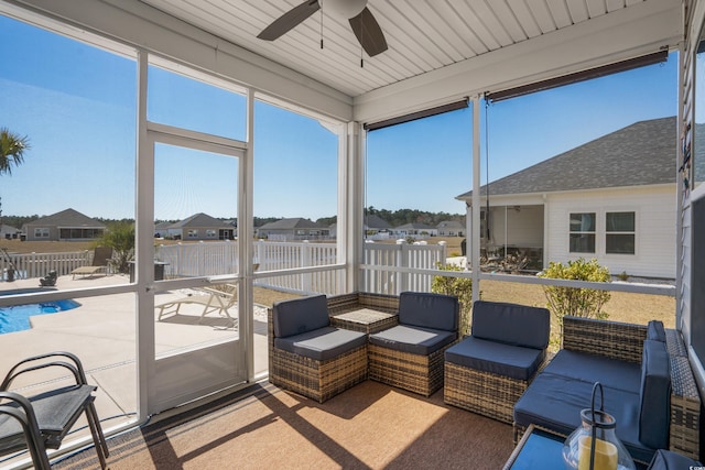 sunroom featuring a residential view and a ceiling fan